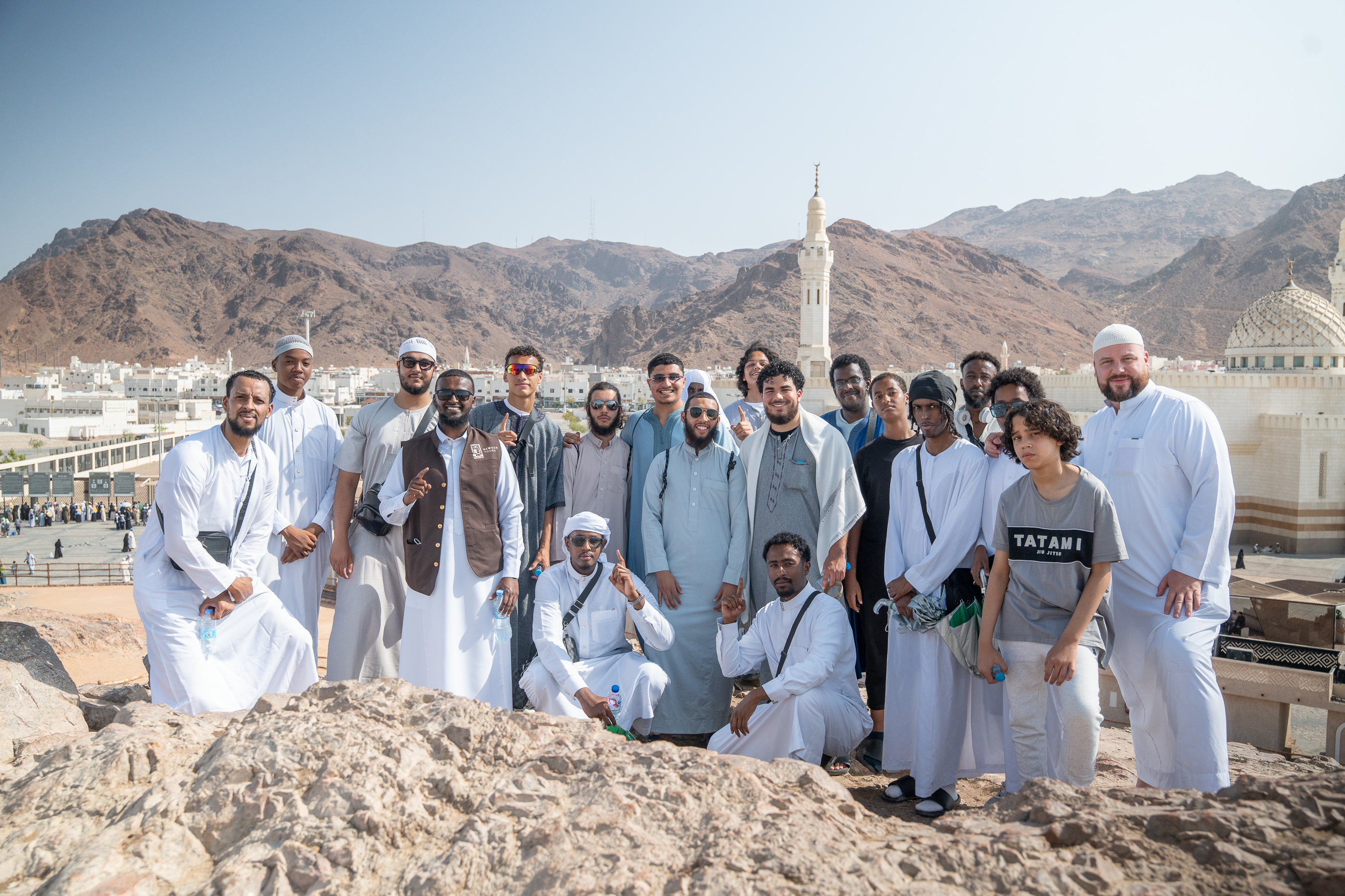 Rawdah Tours pilgrims gathered on a rocky hillside in Madinah